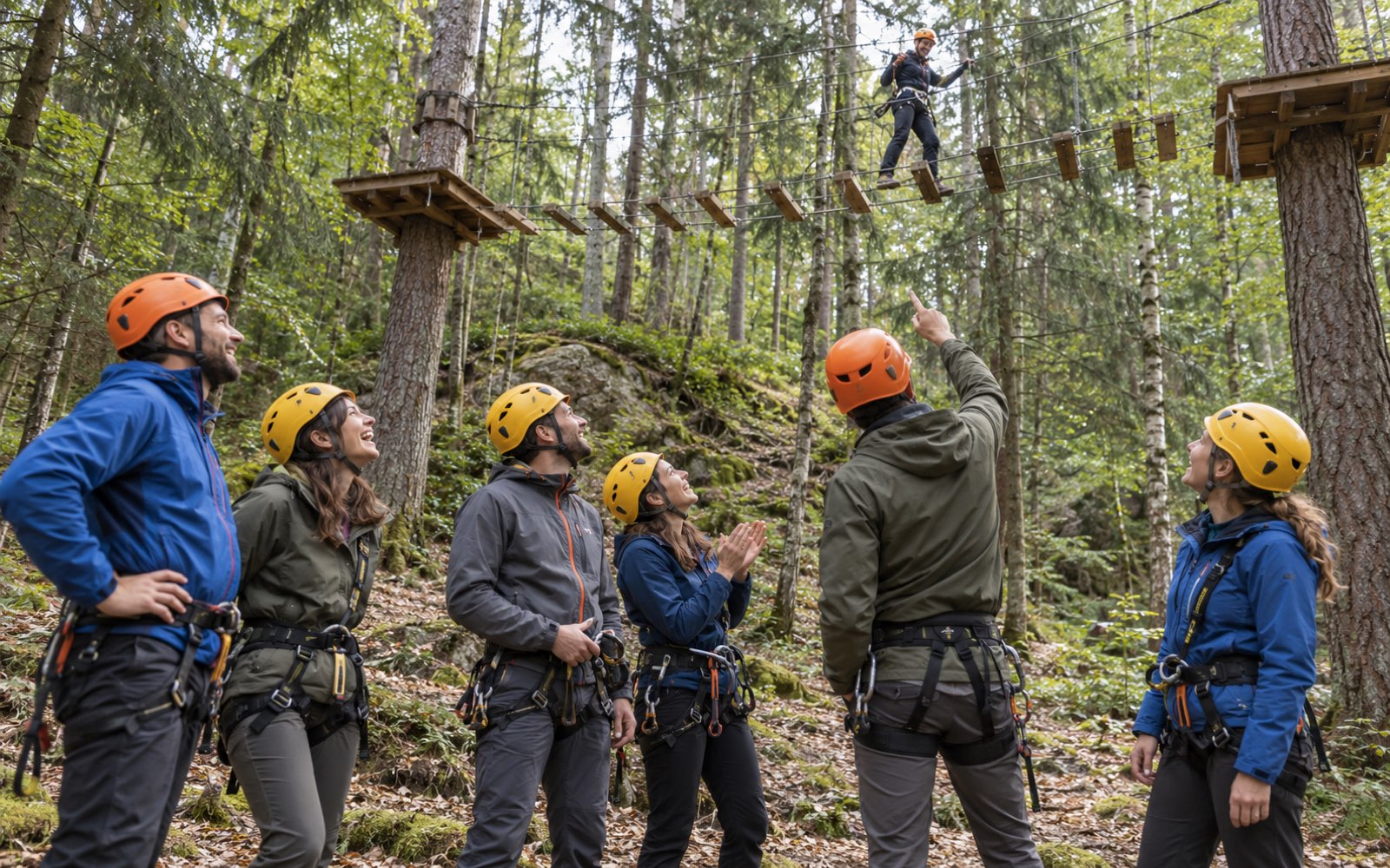 Colleagues cheering on a teammate crossing a bridge above